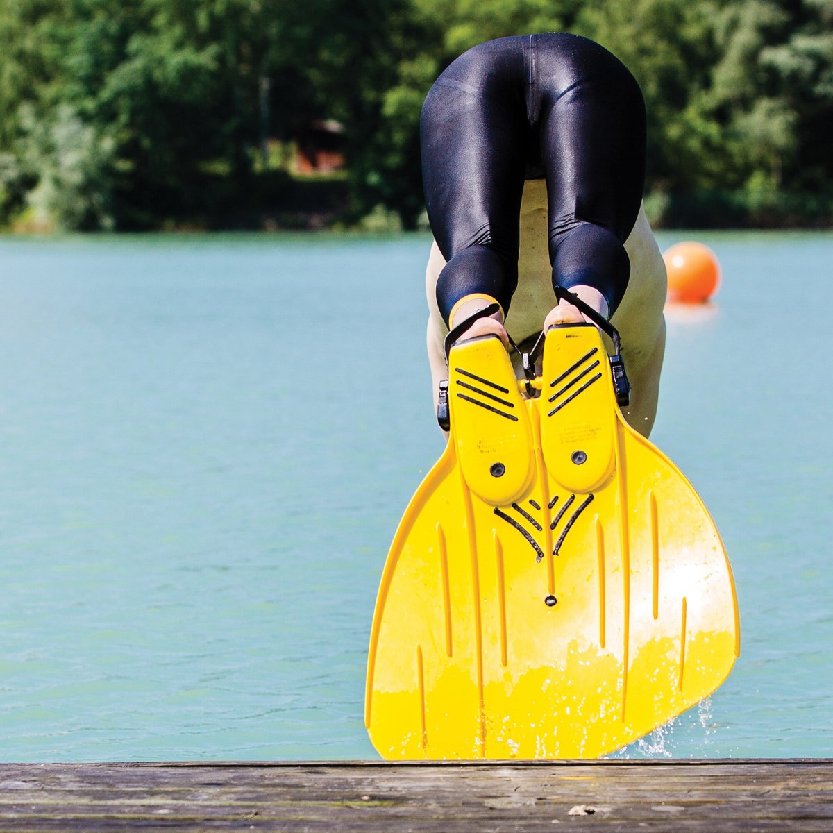 Înotător care se scufundă în lac cu FINIS Rapid Monofin galbenă