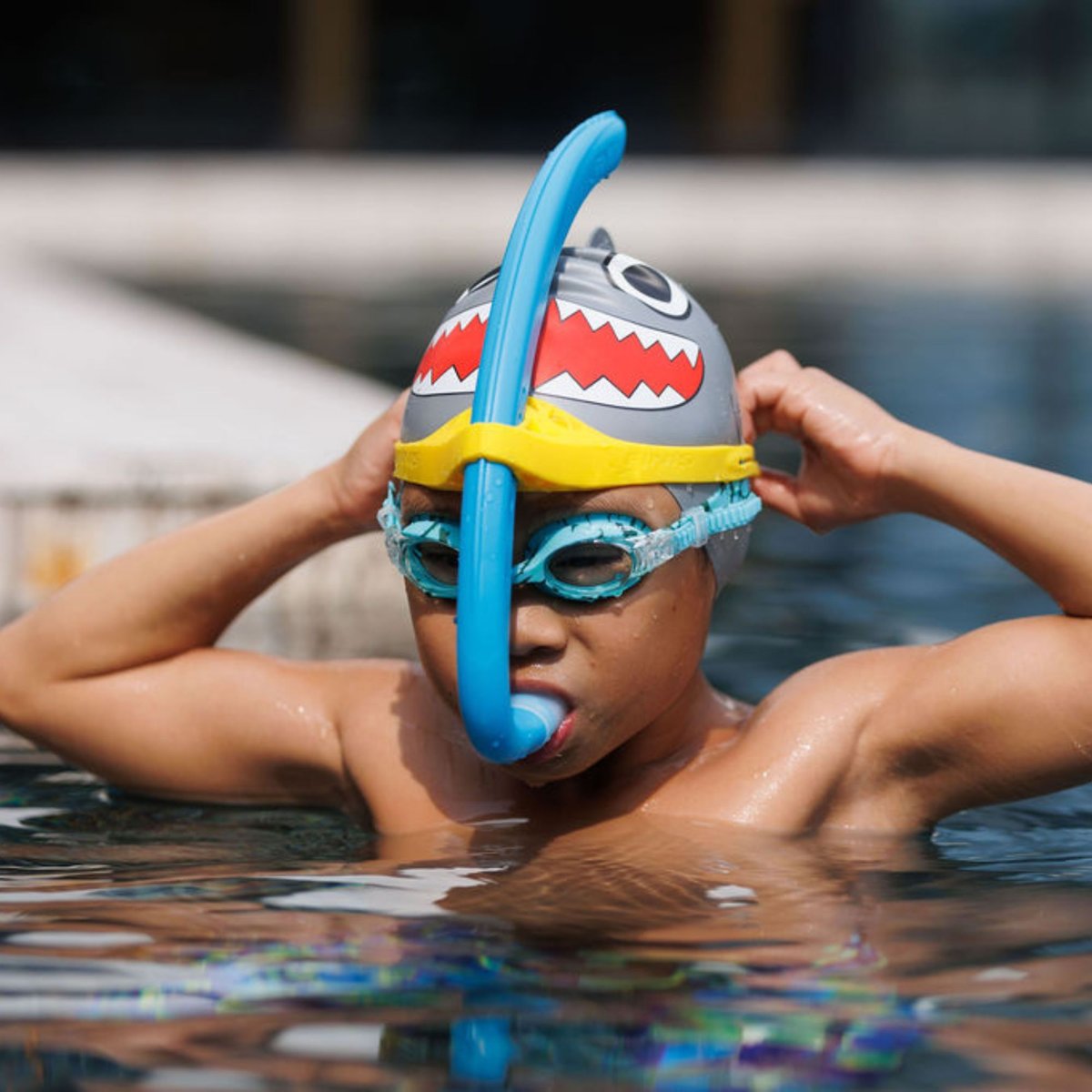 Copil cu FINIS Stability Snorkel Jr albastru, pe marginea bazinului